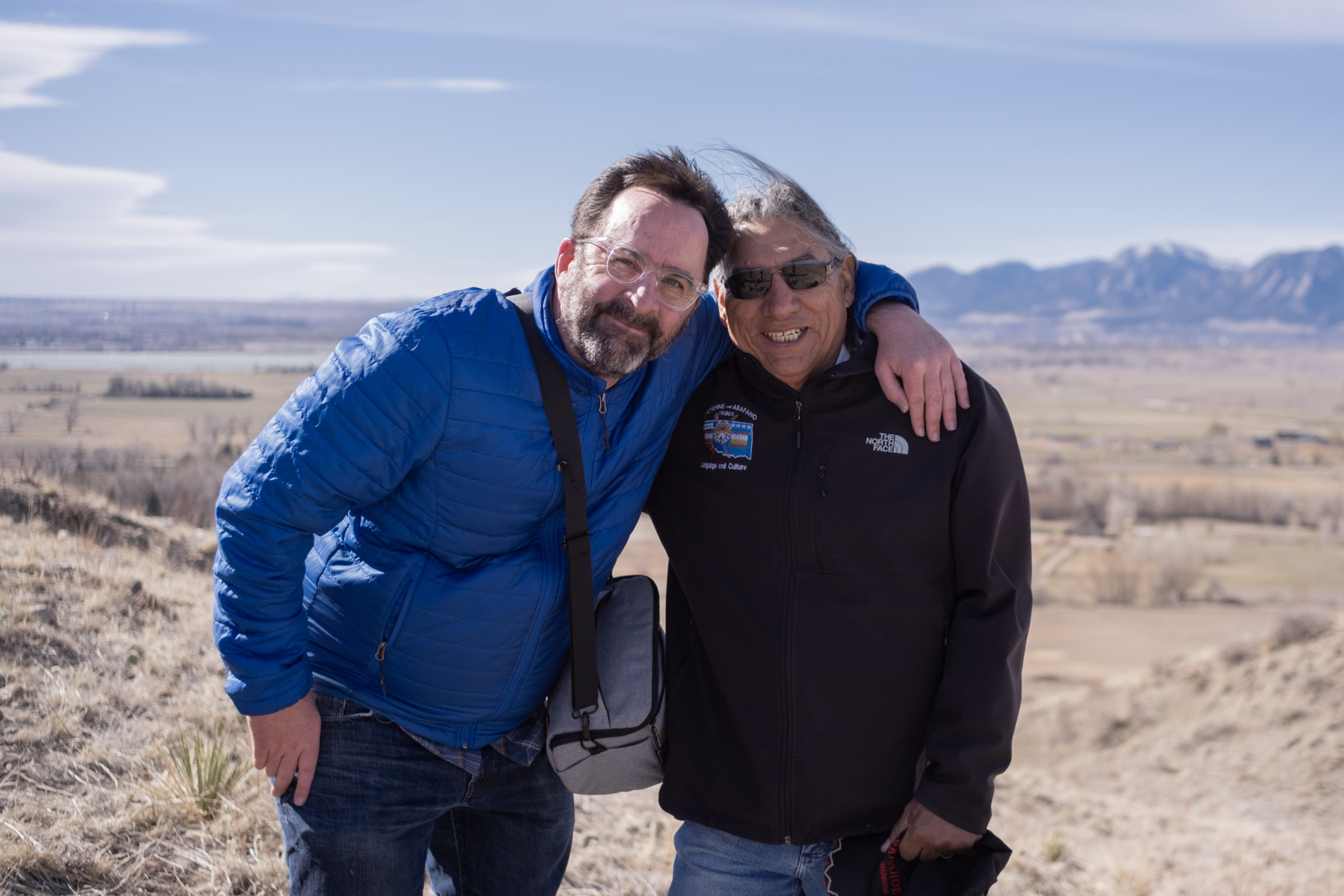 Phillip Yates and Southern Arapaho Elder Fred Mosqueda atop Haystack Mountain with the Flatirons behind them.
