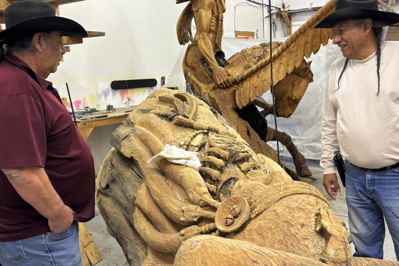 Tribal Representatives viewing Eddie Running Wolf's willow tree carvings in the workshop.